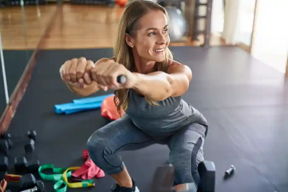 Una persona de 30–40 años haciendo ejercicios con pesas, bandas elásticas o con su propio peso corporal.