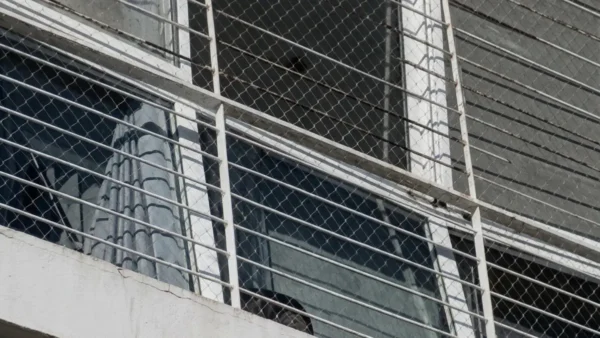 Detalle de una ventana con el marco de aluminio visiblemente torcido y el vidrio roto en el primer piso de la Torre A del complejo Estación Buenos Aires.