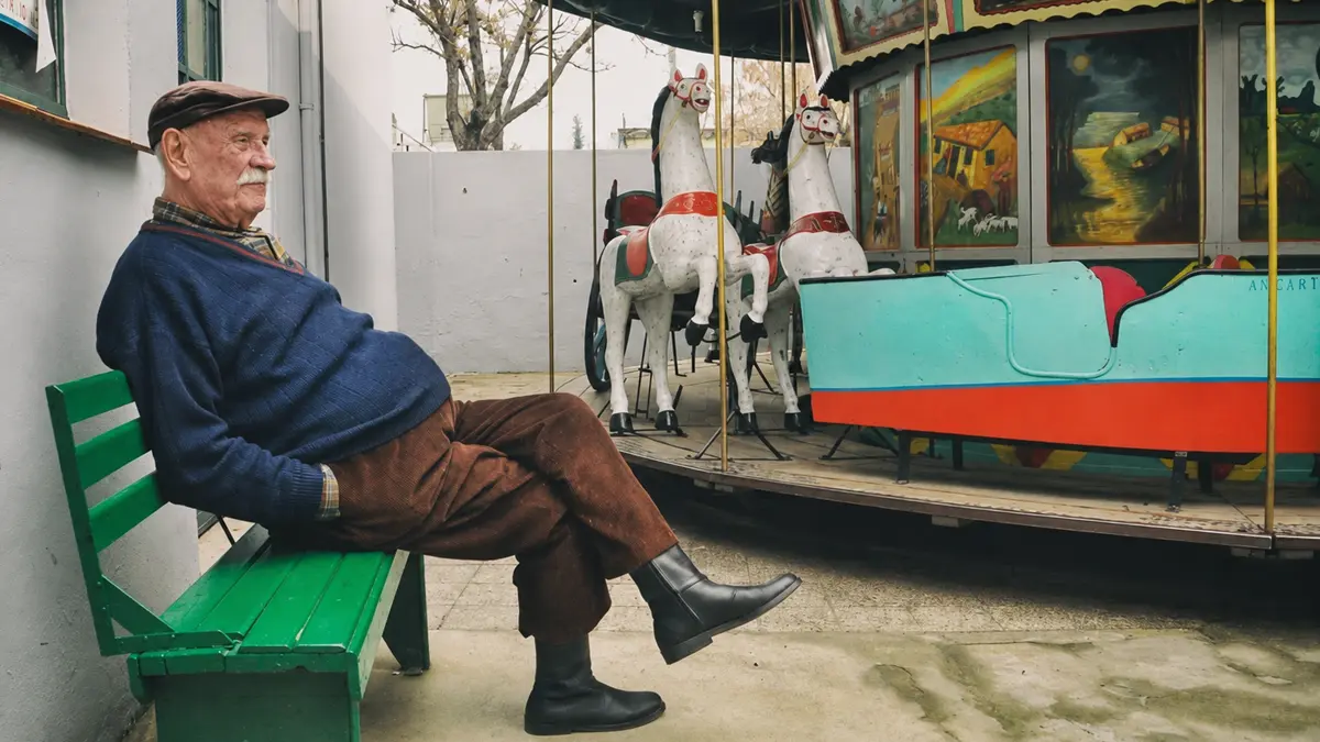 Don Luis junto a la calesita de Liniers que sigue funcionando en el patio de una casa familiar.